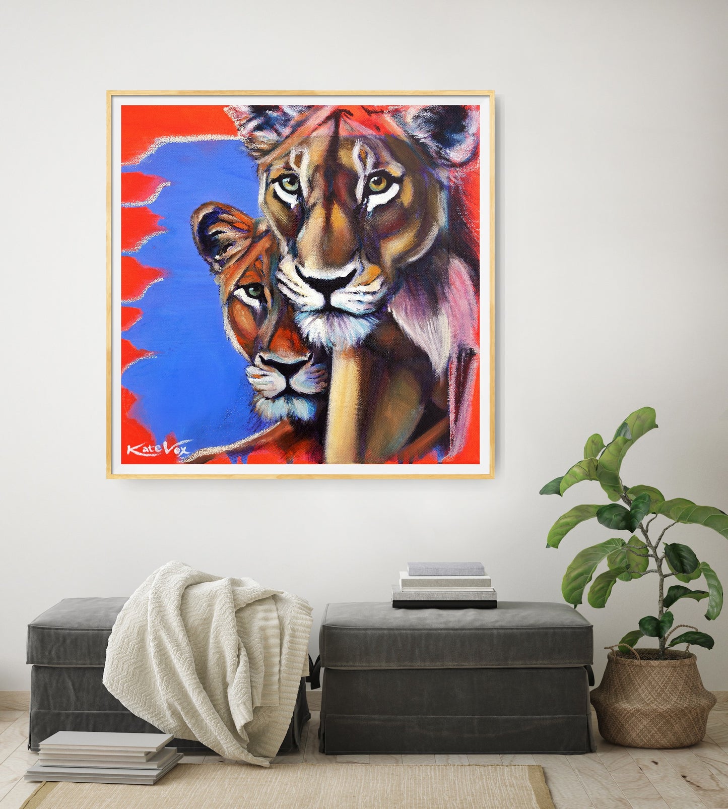 Colorful painting of two lions on a wall above a gray ottoman with a plant to the right.