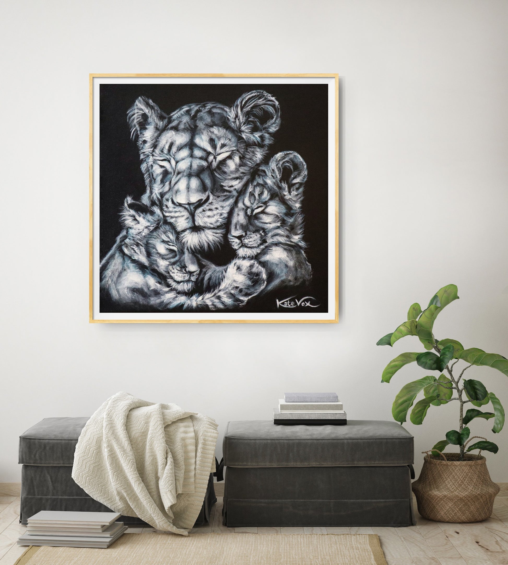 Framed artwork of a lioness and cubs on a wall above a bench with a plant.